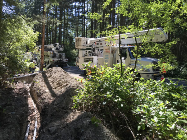 Utilities ditch with conduit by Parker Road with Puget Sound Energy PSE trucks