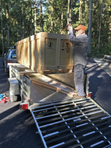 Ken Price opening crate for Jeff Kahn Wind Shear at Price Sculpture Forest sculpture park Coupeville Whidbey Island