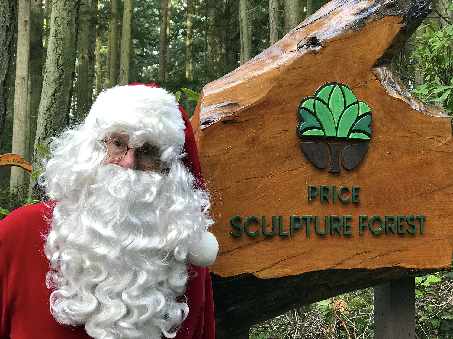 Santa Claus at entrance sign to Price Sculpture Forest park garden in Coupeville on Whidbey Island