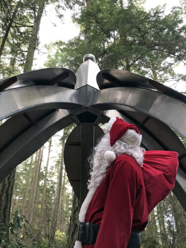 Santa Claus viewing Gary Gunderson's Pentillium at Price Sculpture Forest park garden in Coupeville on Whidbey Island
