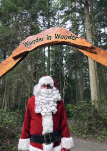 Santa Claus under Wander in Wonder entry arch to Price Sculpture Forest park garden in Coupeville on Whidbey Island