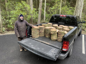 Artist Anthony May with cut log rounds in his truck at Price Sculpture Forest