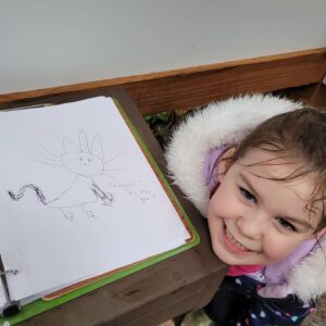 Daughter Mia age 7 draws in Participation Book at Price Sculpture Forest - by Jessica Kanehen of Stanwood WA