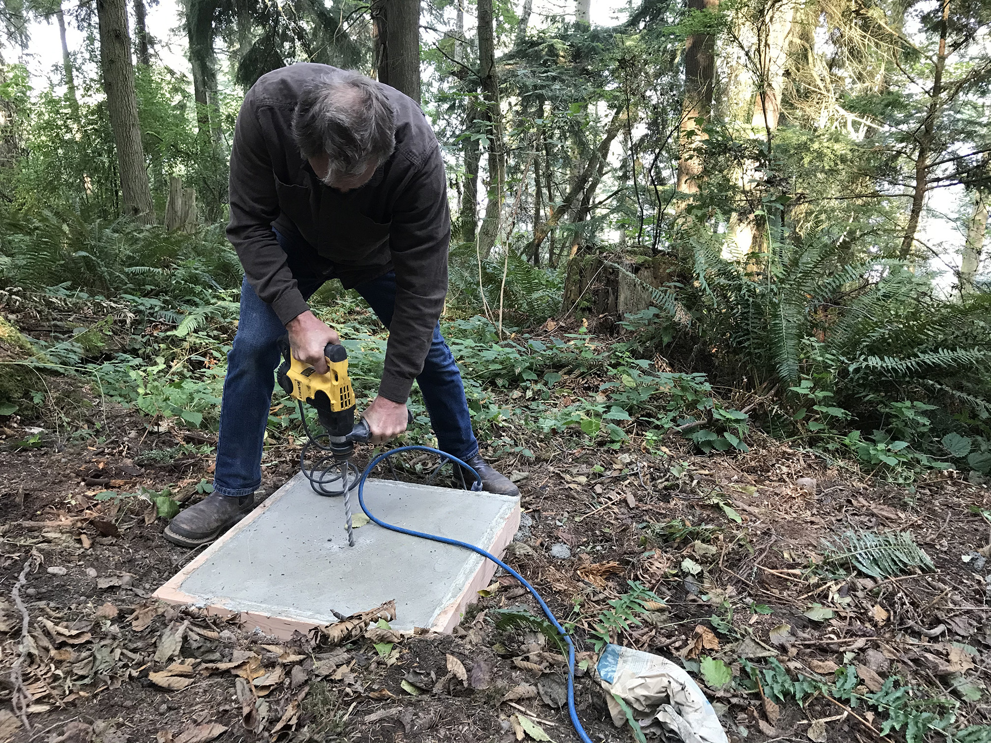 Drilling bolt holes in sculpture base at Price Sculpture Forest