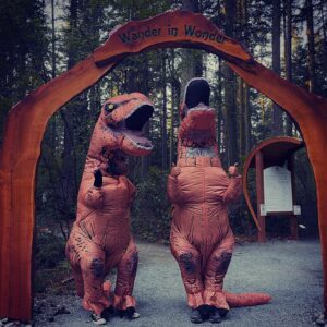 Tyrannosaurus Rex dinosaurs visiting Price Sculpture Forest entry arch - photo and dinosaurs by Jackie Albor of Issaquah WA