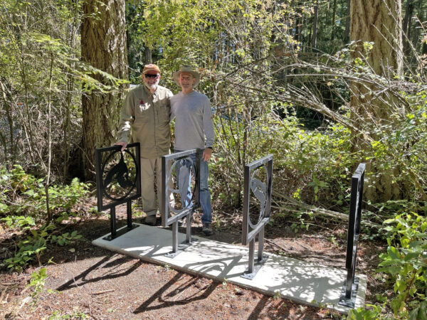 Ken Price and Scott Price with newly installed bike rack in memory of Pat Price at Price Sculpture Forest
