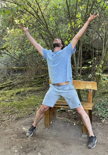 Miles Pertl at bench by Bill Evans in Price Sculpture Forest
