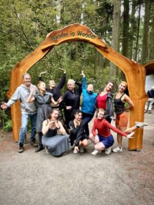 A group of visitors gathered beneath the forest entrance arch