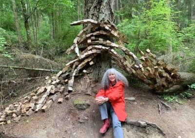 A visitor resting near a natural forest sculpture