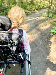 A wheelchair user traveling along a forest path