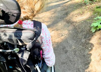 A wheelchair user traveling along a forest path